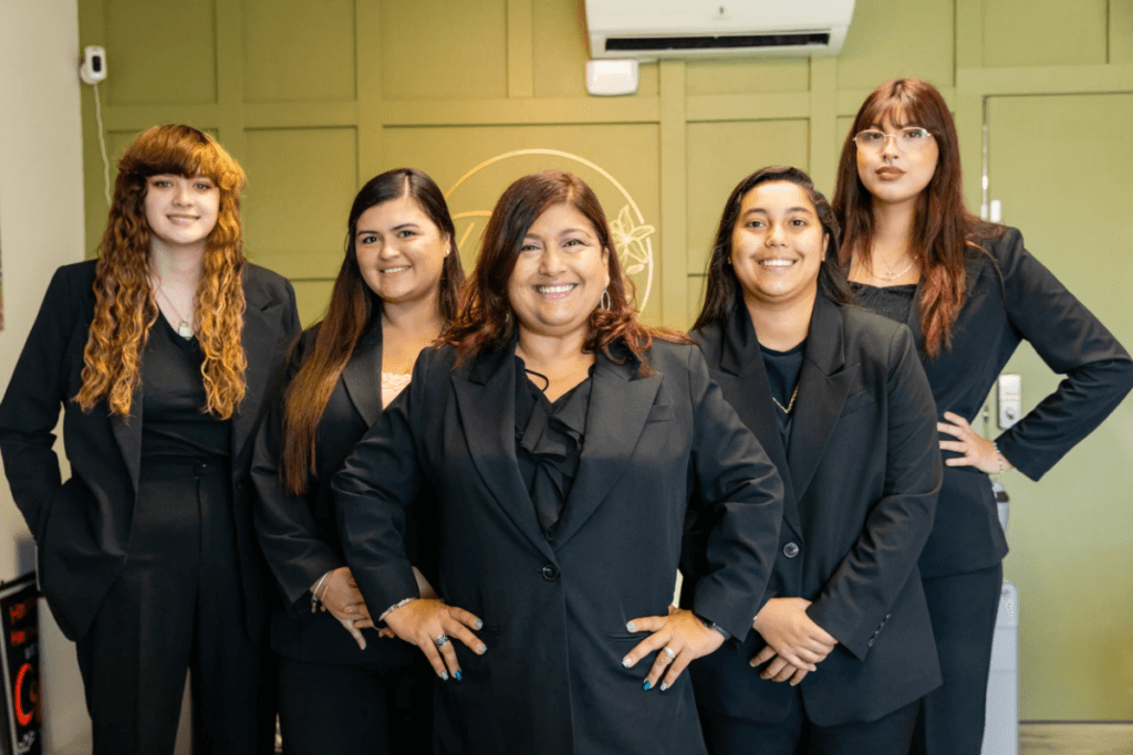 A group of women in black suits posing for the camera.